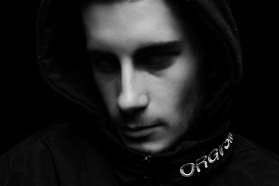 Portrait en clair-obscur d'un homme à capuche