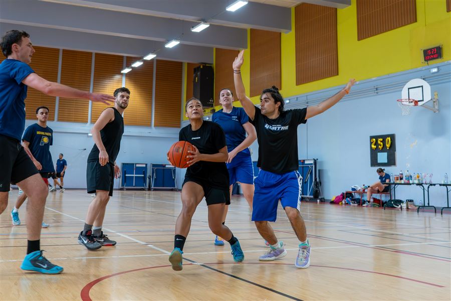 Joueuse de basket dribblant entre les défenseurs