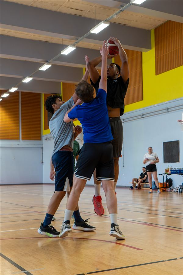 Tir au panier face à un défenseur dans le gymnase