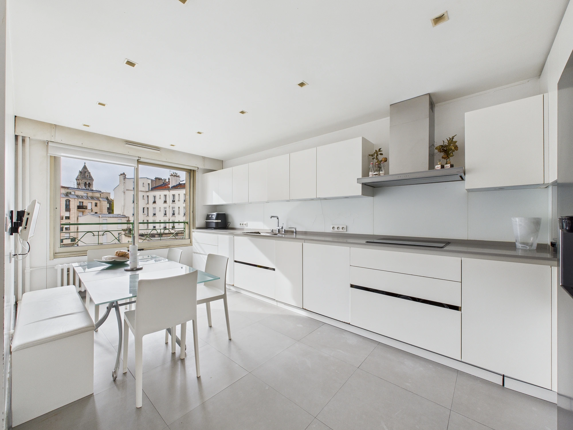 Cuisine blanche contemporaine ouverte sur les toits parisiens