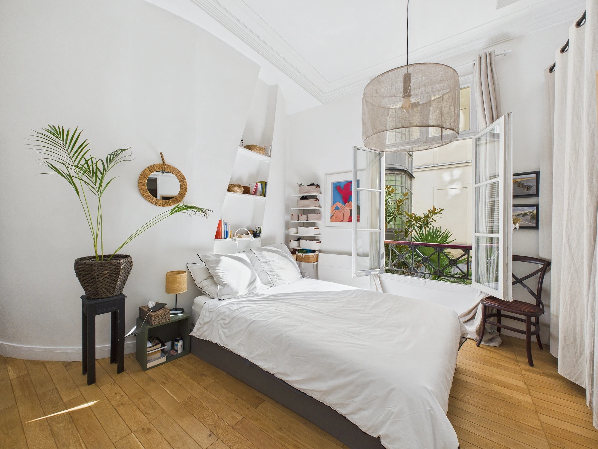 Chambre lumineuse avec suspension en lin et fenêtres ouvertes