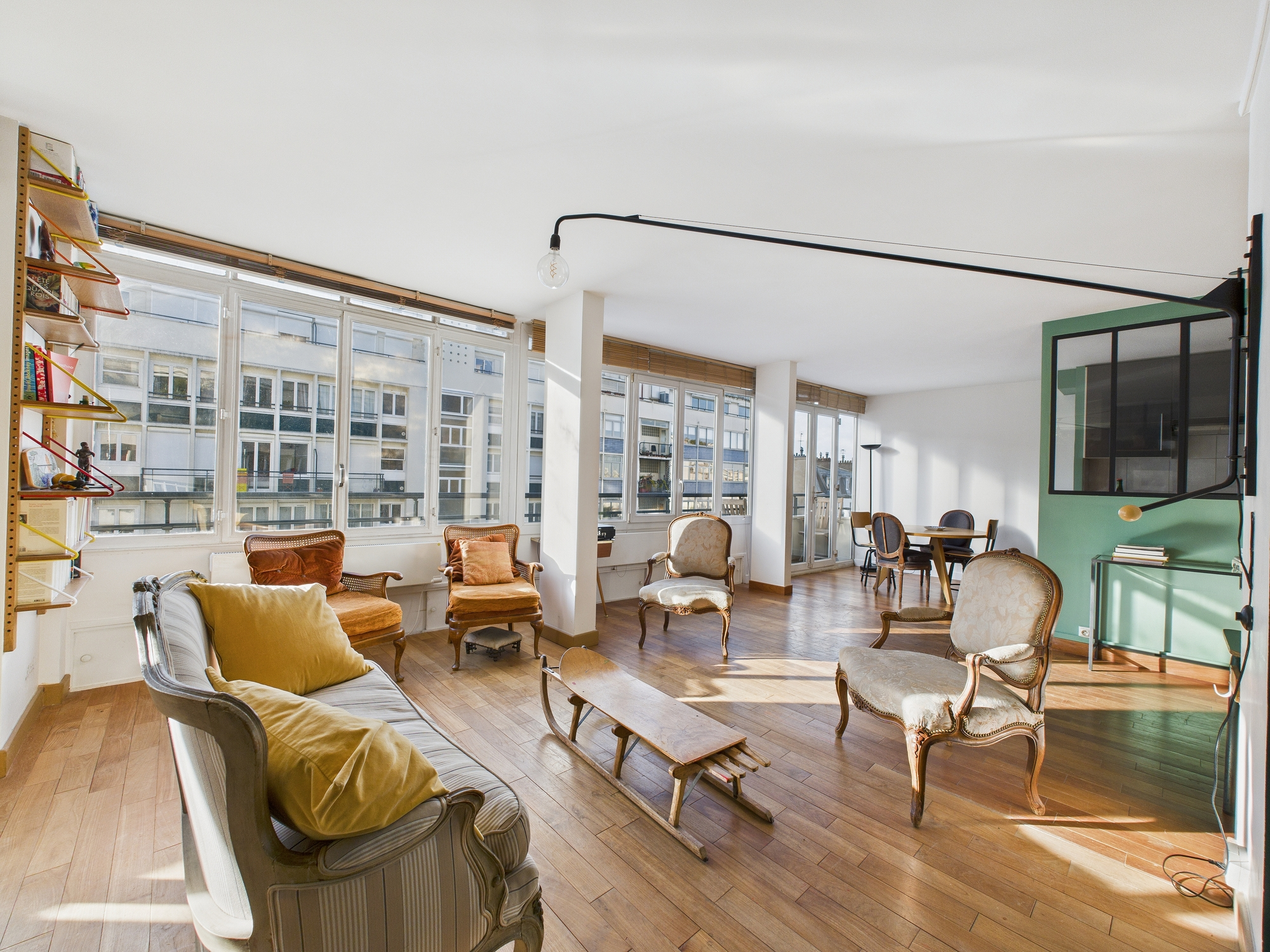 Pièce de vie avec fauteuils et mur vert